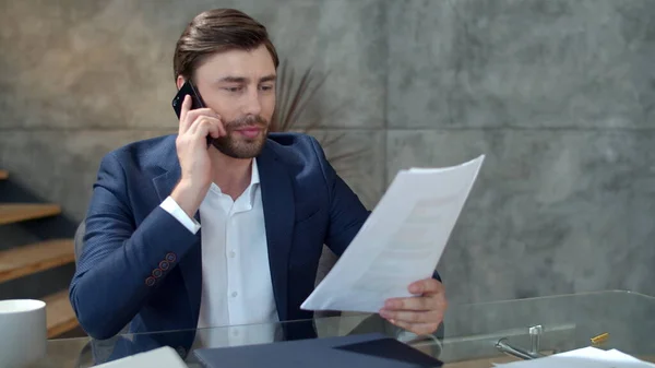 Lächelnder Geschäftsmann telefoniert am Arbeitsplatz. Glücklicher Mann beim Lesen von Dokumenten — Stockfoto
