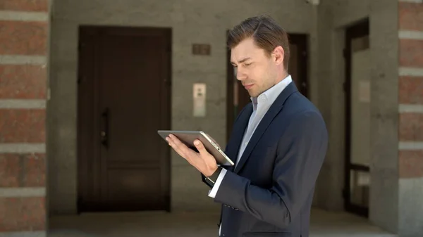 Closeup businessman holding tablet at street. Man using tablet for work outdoor
