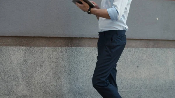 Nahaufnahme Geschäftsmann zu Fuß mit Tablet. Mann bekommt gute Nachrichten auf Tablet im Freien — Stockfoto