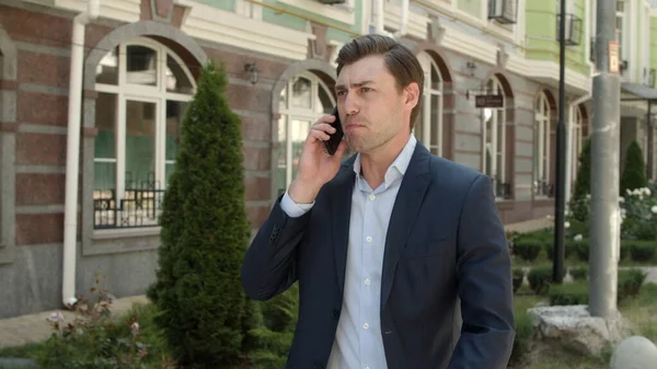 Człowiek z bliska rozmawiający przez telefon na świeżym powietrzu. Człowiek omawiający sprawy biznesowe na ulicy — Zdjęcie stockowe