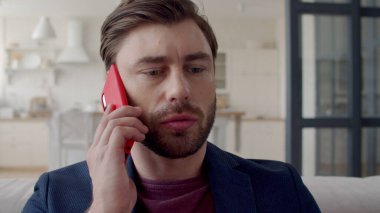 Uzak ofisteki genç iş adamı şüpheye düşüyor. Akıllı telefondan konuşan adam..