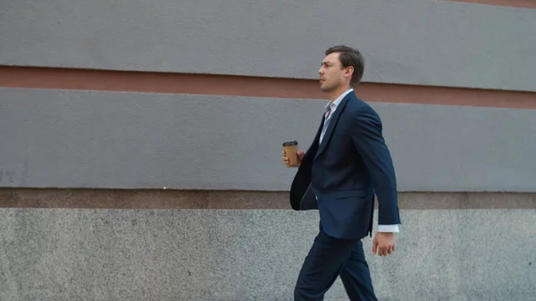 Σοβαρός άνθρωπος που περπατάει με καφέ στο δρόμο. Ο άνθρωπος πηγαίνει σε συνάντηση με τον καφέ — Φωτογραφία Αρχείου