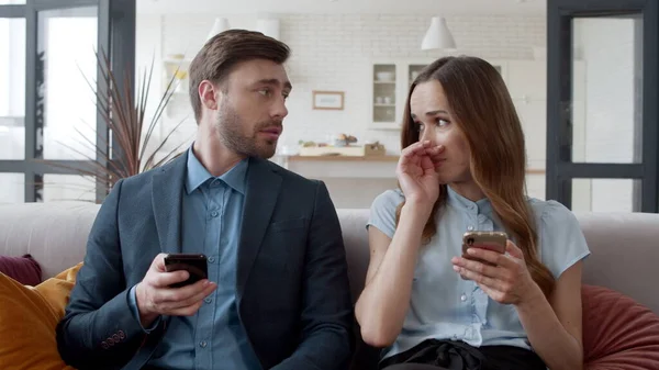 En ung kvinne som snakker med mannen sin hjemme. Nettlesing av Internett på telefon. – stockfoto