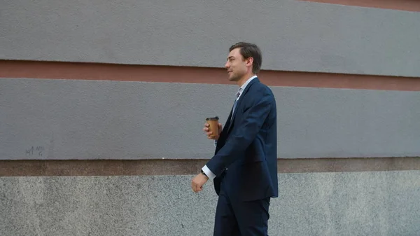 Χαμογελώντας άνθρωπος πίνοντας καφέ στο δρόμο. Επιχειρηματίας με τα πόδια στην εργασία με καφέ — Φωτογραφία Αρχείου