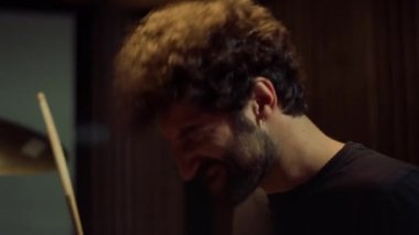 Müzisyen kayıt stüdyosunda rock müzik yapıyor. Davulcu rock müzik çalıyor.