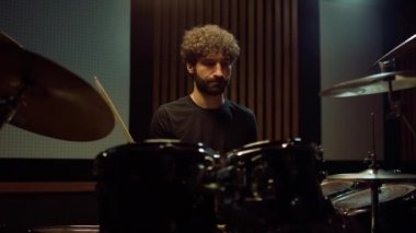 Konser salonunda rock müzik yapan müzisyen. Davulcu içeride davul çalıyor..