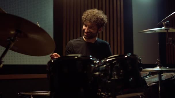 Vrolijke muzikant spelen op drum kit indoor. Vreugdevolle kunstenaar die plezier heeft in de hal. — Stockvideo