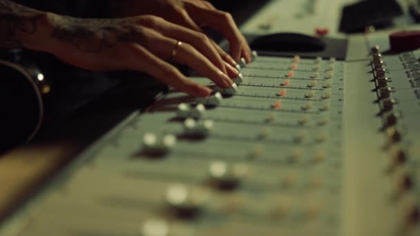 Zvukový technik pohybuje posuvníky na ovládacím stole. Mužské ruce dotýkají soundboardu. — Stock video
