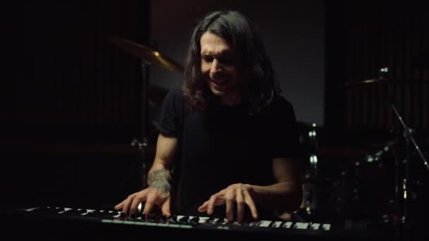 Un homme satisfait jouant dans le couloir sombre. Un gars souriant répétant dans un studio de musique. — Video