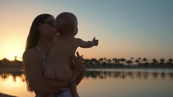 휴식을 취한 어머니와 귀여운 소년이 리조트 해변에서 아름다운 일몰을 즐긴다. — 비디오
