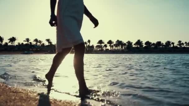 Ragazza sconosciuta che cammina in acqua di mare calda all'alba. Donna gambe spruzzi d'acqua — Video Stock