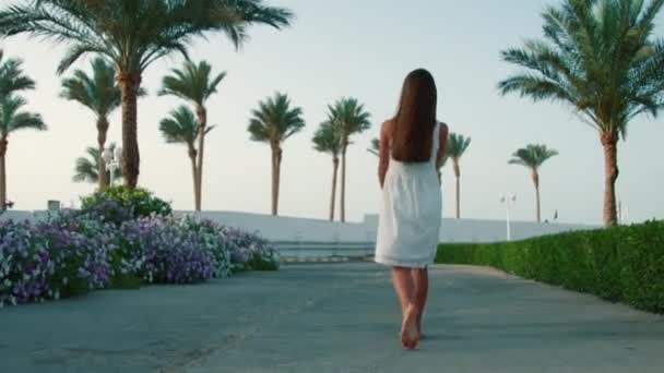 Egy tini lány sétál az egzotikus parkban. Fiatal nő élvezi a nyári vakációt. — Stock videók