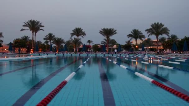 Piscina ao pôr do sol no resort de baixa temporada. Belo panorama da piscina ao ar livre. — Vídeo de Stock