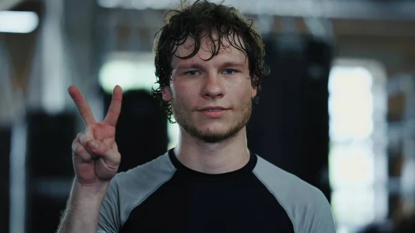 Smiling kickboxer making gestures at gym. Fighter showing fuck in sport club — Fotografia de Stock