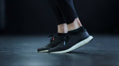 Adam ağır çekimde bacak değiştiriyor. Beden eğitiminde kickboxer ayaklarında yan görünüm