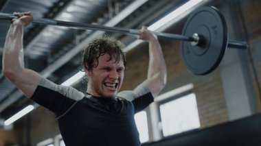 Hırslı sporcu spor kulübünde ağırlık kaldırıyor. Kickboksör güç gösteriyor