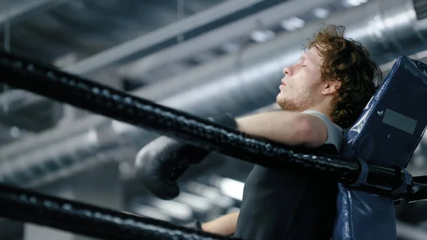 Üzgün kickboksör spor salonunda dövüşü kaybediyor. Üzgün sporcu ringde duruyor. — Stok fotoğraf