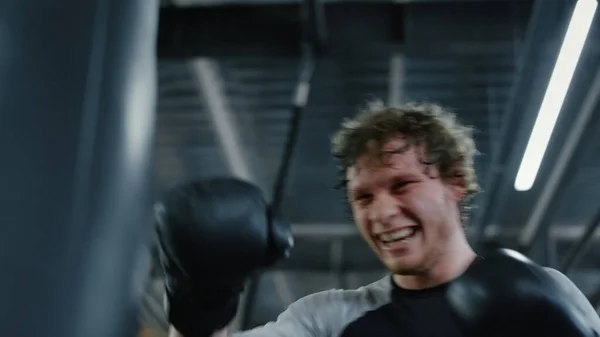 Kickboxer agressivo batendo saco de perfuração no centro de fitness. Esportista boxe — Fotografia de Stock