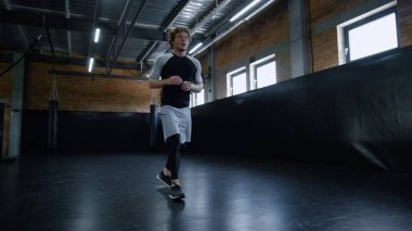 Spor kulübünde hırslı bir boksör ısınıyor. Sporcu spor salonunda tekrarlıyor.