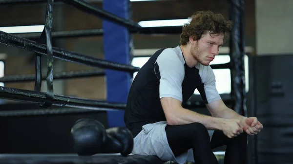 Strach bojovník čeká na boj ve fitness centru. Kickboxer sedí v tělocvičně — Stock fotografie