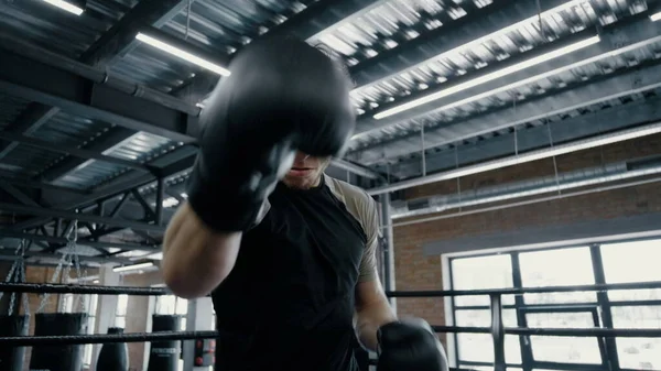Sportovní boxer cvičí v posilovně. Sportovec ukazující agresivitu na ringu — Stock fotografie
