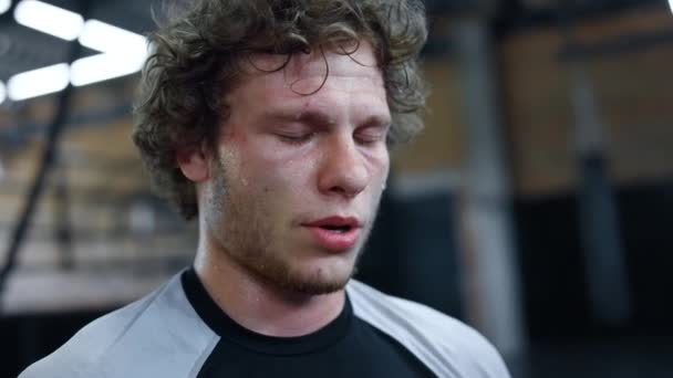 Una goccia di sudore che cade dalla faccia da lottatore nello sport club. Kickboxer in piedi in palestra — Video Stock