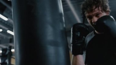 Stres savaşçısı fitness merkezinde darbe vuruyor. Sporcu spor salonunda vuruşlar yapıyor.