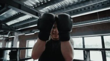 Spor salonunda zafer savaşçıları bağırıyor. Sporcu ringde güç gösteriyor
