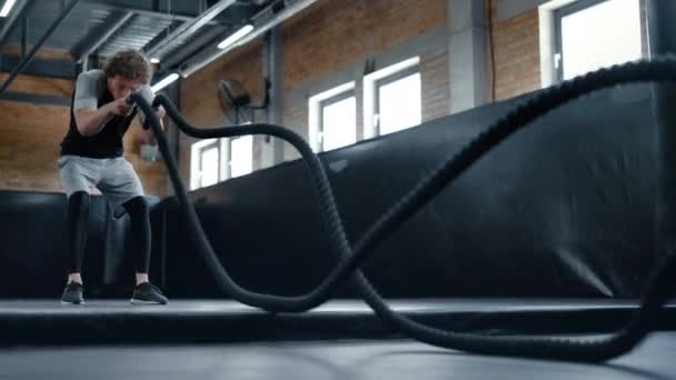 Sorgenvolles Kickboxtraining mit Seilen im Sportverein. Kämpferin mit Seilen in Turnhalle — Stockvideo