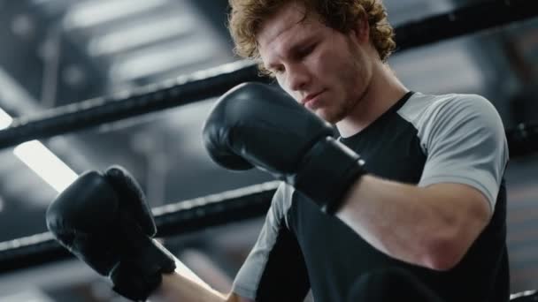 Luchador enfocado a la espera de pelea en el club deportivo. Kickboxer con guantes de boxeo — Vídeos de Stock