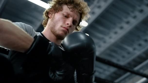 Kickboxer si nasazuje boxerské rukavice. Striktní bojovník bít ruce ve sportovním klubu — Stock video