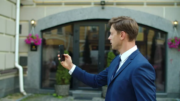 Smiling business man having video conference online outdoors.