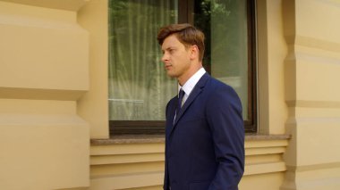 Düşünceli iş adamı ağır çekimde yürüyor. Kendine güvenen bir iş adamı.