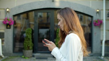 Dışarıda telefonu kullanan bir iş kadını. Mutlu kadın dışarıda iyi haberler alıyor.