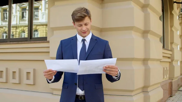 Portrait of successful business man reading documents outdoors — Stock Photo, Image