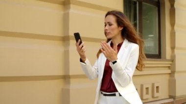 Kapanış kızı dışarıda elini hareket ettiriyor. Kadın profesyonel dışarıda video görüşmesi yapıyor.