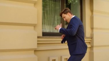 Neşeli iş adamı dışarıda zaferi kutluyor. Mutlu iş adamı dansı