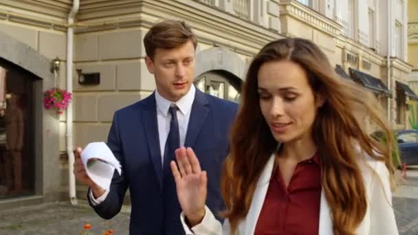 Blízký pár diskutující o dokumentech na ulici. Muž a žena mluví chodník — Stock video