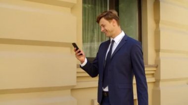 Neşeli iş adamı dışarıda cep telefonu kullanıyor. Mutlu profesyonel