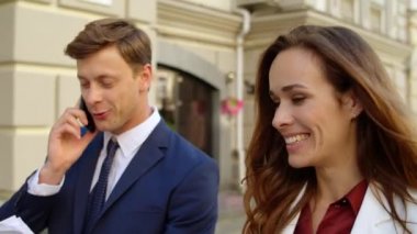 İş çifti sokakta telefonla proje sunuyor. Dışarıda telefonla konuşan bir adam.