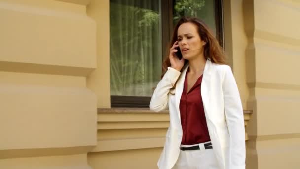 Closeup disappointed woman walking at street. Business woman talking phone — Stock Video