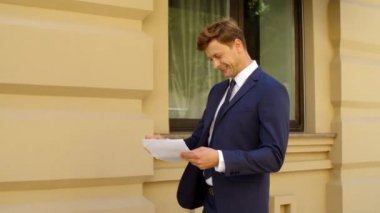 Açık havada finansal belgeleri okuyan başarılı bir iş adamı.