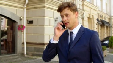 Fotoğrafçı sokakta cep telefonuyla konuşuyor. İş adamı açık havada akıllı telefon kullanıyor.