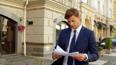 Odaklanmış iş adamı dışarıda evrak okuyor. Profesyonel düşünüyorum.