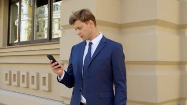 Dışarıda cep telefonu kullanan ciddi bir iş adamının portresi.