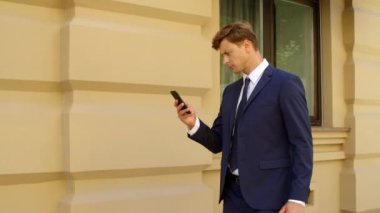 Açık havada cep telefonu kullanan odaklanmış bir iş adamı. Düşünceli iş adamı.