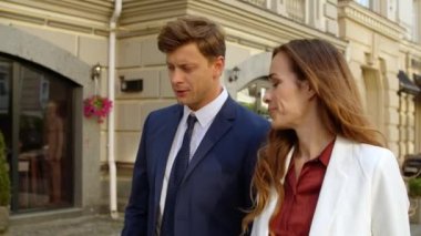 Kapanış adamı ve kadın iş tartışıyorlar. İş çifti kaldırımda birlikte yürüyor