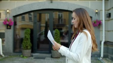 Heyecanlı kadın şehir caddesinde başarının tadını çıkarıyor. Odaklanmış iş kadını