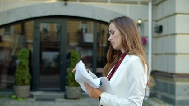 Mujer de negocios seria leyendo documentos al aire libre. Mujer analizando documentos — Vídeo de stock