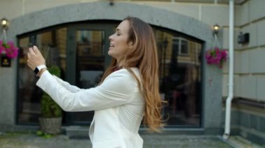 Dışarıdaki akıllı telefondan görüntülü arama yapan gülümseyen kadın.